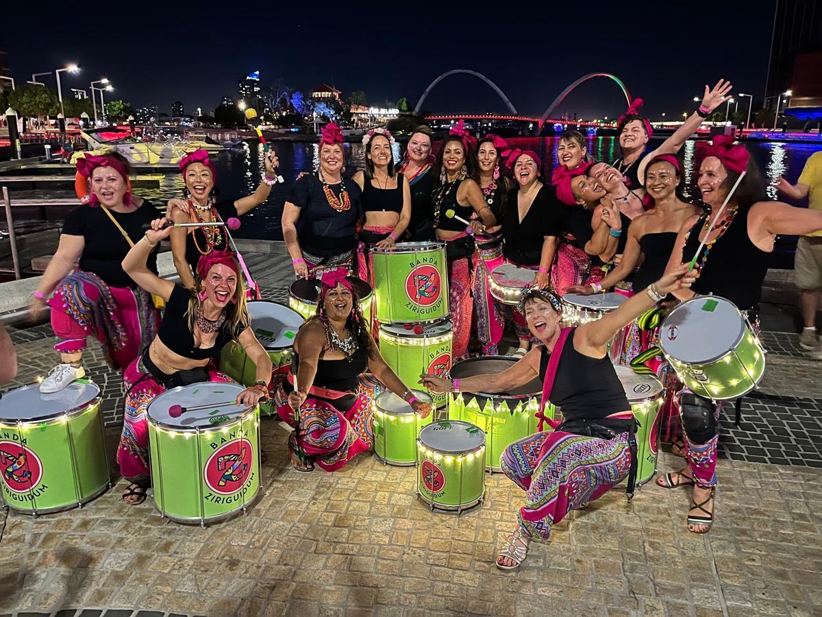 The full Banda Ziriguidum bateria with lit drums on the Perth waterfront at night